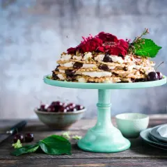 Patera do serwowania przekąsek z wafelkowym ciastem, kremem i wiśniami, ozdobiona kwiatami.