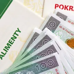 Dokumenty i banknoty 100 zł. Widoczne napisy "ALIMENTY" i "POKRZYWDZONY". Symbolizuje to, jak komornik przelewa alimenty.