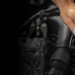 Mano limpiando el logo de Mercedes-Benz. Un detalle para el reset mantenimiento Mercedes.