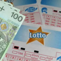 Banknot 100 zł leży obok kuponów Lotto. Czy tym razem będzie to trafiony wybór, czy jednak chybił trafił?