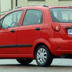 Czerwony Chevrolet Matiz, model Spark, zaparkowany na ulicy.