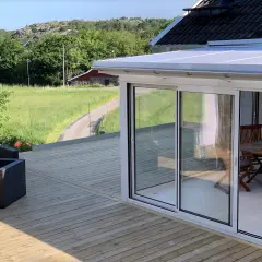 Nybyggd altan med glaspartier och utemöbler. Tänk på att bygga altan utan bygglov kan leda till straff.