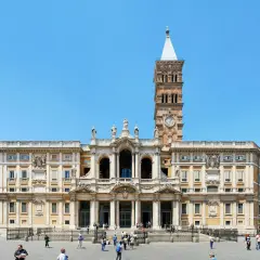Bazylika Santa Maria Maggiore w Rzymie, z charakterystyczną wieżą zegarową, na tle błękitnego nieba.