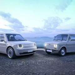 Nowy Fiat 126p obok swojego klasycznego poprzednika, na tle wodnego miasta.