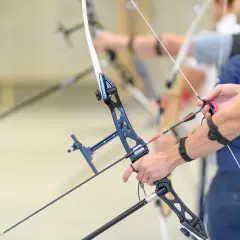 Łuczniczka napina łuk, czując siłę naciągu. Strzała gotowa do lotu.