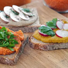 Herzhafte Brotaufstriche selber machen: Rote Linsen-Aufstrich mit Rucola, Pilz-Aufstrich mit Dill und gelber Aufstrich mit Radieschen auf Vollkornbrot.