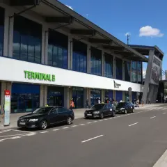 Taksówki czekają przed Terminalem B lotniska Katowice-Balice, gotowe na podróż do Krakowa.