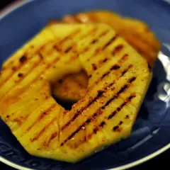 Tranches d'ananas grillées sur une assiette bleue.