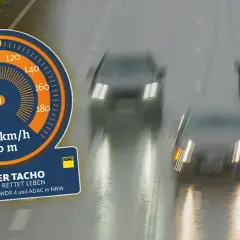 Tacho-Anzeige zeigt 100 km/h bei 50 m Abstand. Kampagne "Halber Tacho" mahnt zu mehr Sicherheitsabstand auf nasser Fahrbahn.