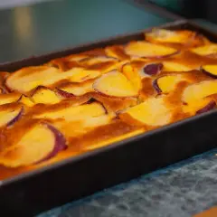 Clafoutis aux pêches dorées, tout juste sorti du four, prêt à être dégusté.