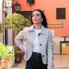 Mujer con chaqueta clara y vaqueros oscuros, lista para un outfit de Semana Santa.