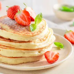 Pancakes soffici con fragole e menta, una deliziosa colazione proteica dolce per iniziare la giornata con energia.