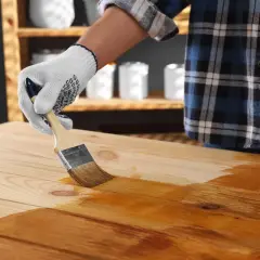 Application d'une première couche de vernis sur un plateau en bois. On se demande combien de couche de vernis bois seront nécessaires pour un fini parfait.