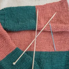 Kolorowy, dziergany sweter z drutami i szydełkiem.