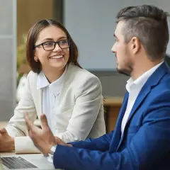 Ein Mann und eine Frau besprechen am Laptop die Gehaltsentwicklung einer Finanzwirtin.