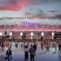 Tłum kibiców zmierza na mecz do Inter Miami Stadium. Zachodzące słońce maluje niebo na różowo, a stadion lśni w różowych barwach.