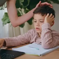 Chłopiec zapatrzony w ekran, z ręką na głowie, wygląda, jakby gdy dziecku na niczym nie zależy. Mama próbuje go zachęcić.