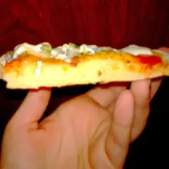 Kawałek puszystej pizzy z serem i sosem, wygląda jak pizza jak z Pizza Hut.