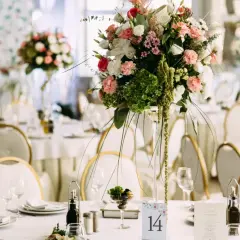 Elegancka dekoracja stołu weselnego z bukietem kwiatów i numerem 14. Sprawdź wedding planner cena, by zorganizować wymarzone przyjęcie.