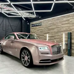 Luksusowy Rolls-Royce w różowym odcieniu, prezentujący efektowne oklejenia samochodu.
