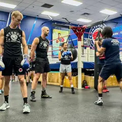 Boxers practice their pivot boxing moves in a gym.