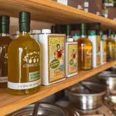Bouteilles d'huile d'olive "Les Sens de Notre Terre", "A l'ombre de l'Oli" et "La Sélection du Luberon", évoquant les saveurs des terrasses d'Adrien.