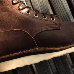 Brown leather boot with white sole. The stitching and laces are visible. This boot might make noise when you walk if the sole is loose.