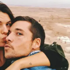 Laura Matamoros y Benji se dan un tierno beso en un paisaje desértico con tiendas de campaña.