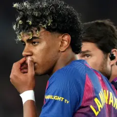 Młody piłkarz Lamine Yamal z FC Barcelony, z charakterystyczną fryzurą, zamyślony, być może po kontuzji.