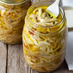 Melanzane sott'olio alla napoletana, un tesoro di sapori in barattolo. Una forchetta assaggia questa delizia.