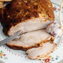 Soczysty schab pieczony w rękawie, pokrojony w plastry, z czosnkiem i pieczywem.
