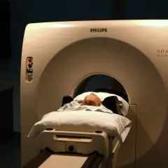 Pacjent leży na łóżku aparatu do tomografii głowy Philips ADAC Allegro.
