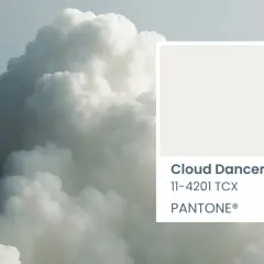 A soft, ethereal cloud formation, reminiscent of a cloud dancer, is paired with the Pantone color swatch for Cloud Dancer 11-4201 TCX.
