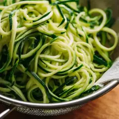 Frisch zubereitete gedrehte Nudeln aus Zucchini in einem Sieb.