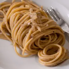 Un piatto di bigoli con le sarde, pasta fresca condita con un sugo saporito.