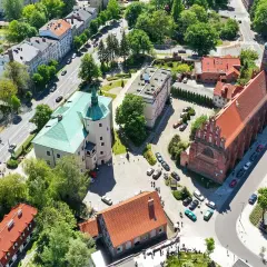 Słupsk atrakcje: widok z lotu ptaka na zamek Książąt Pomorskich z zielonym dachem i ceglany kościół.