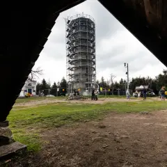 Wielka Sowa szlaki turystyczne prowadzą do wieży widokowej w rusztowaniach. Ludzie spacerują po placu.
