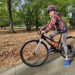 Dziewczynka na rowerze, idealny rower dla 10 latka ile cali? W parku jesienią.