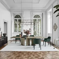 Sala da pranzo con tavolo e sedie in stile mid century modern, illuminata da un lampadario a sfere e con un mobile basso in legno scuro.
