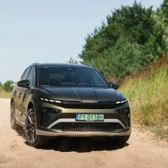 Zielona Skoda Enyaq na piaszczystej drodze, testowana pod kątem zasięgu.