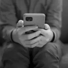 Dłonie trzymające telefon, symbolizujące uzależnienie od telefonu.