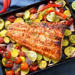 Delicioso pescado al horno con patatas, tomates, cebolla y pimientos. Un plato completo y sabroso.
