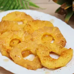 Rodajas de piña a la plancha, doradas y jugosas, espolvoreadas con canela. Un postre tropical irresistible.
