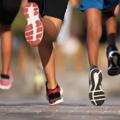 Des coureurs en action, leurs pieds chaussés de baskets s'élancent sur le bitume. Ils font du footing, une course dynamique et énergique.