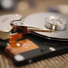 Nahaufnahme einer geöffneten Festplatte, die zeigt, wie die Lese-/Schreibköpfe über die Spindeln gleiten. Dies ist ein Beispiel für die Technologie, die früher für die Datenverwaltung verwendet wurde, bevor SSDs mit TRIM-Funktion aufkamen.