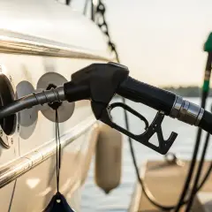 Pompa di rifornimento inserita nello scafo di una barca, con il sole che illumina la scena. Il costo del gasolio nautico è un pensiero comune.