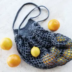 Borsa a rete uncinetto facile, perfetta per la spesa. Contiene limoni e arance, pronta per un picnic.