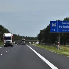 Droga ekspresowa S12 w kierunku Toruń Południe. W oddali widać wiadukt i inne pojazdy.