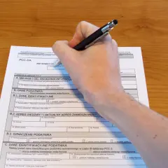 Dłoń pisze na formularzu PCC-3/A, wypełniając dane podatnika.