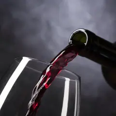 Ciemnoczerwone, bogate montalcino wino leje się z butelki do kieliszka, tworząc kaskadę smaku.